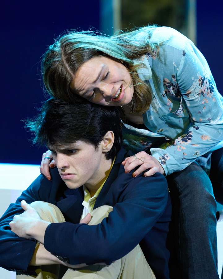 An upset student is comforted by a woman.