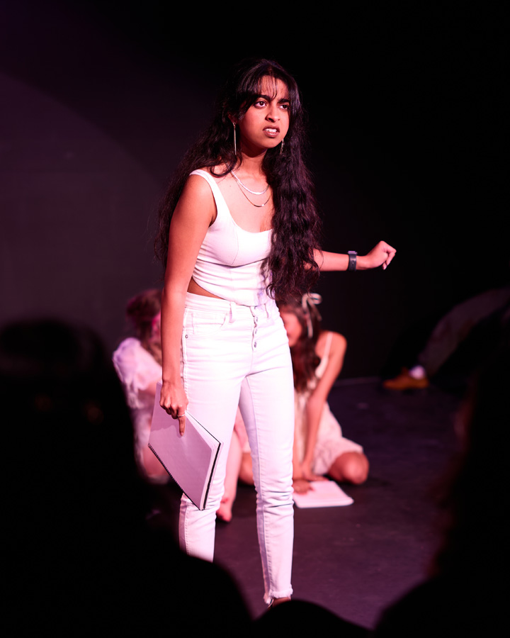 A woman in white talking to someone off-screen.