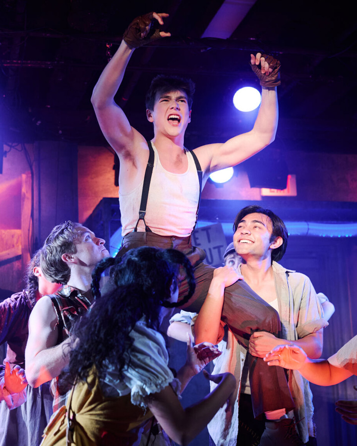 A group of people hoist a man up onto their shoulders.