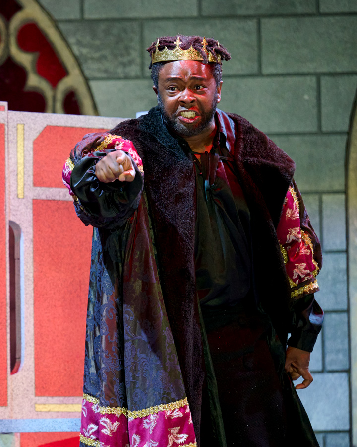 A king gesturing at someone out of frame.