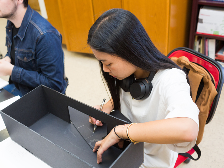 Photo of students building models in the design studio.