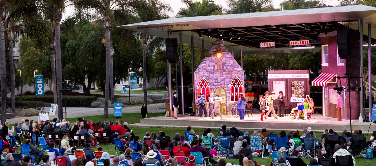 A view of the stage during a performance of The Comedy of Errors, with the audience in the foreground.