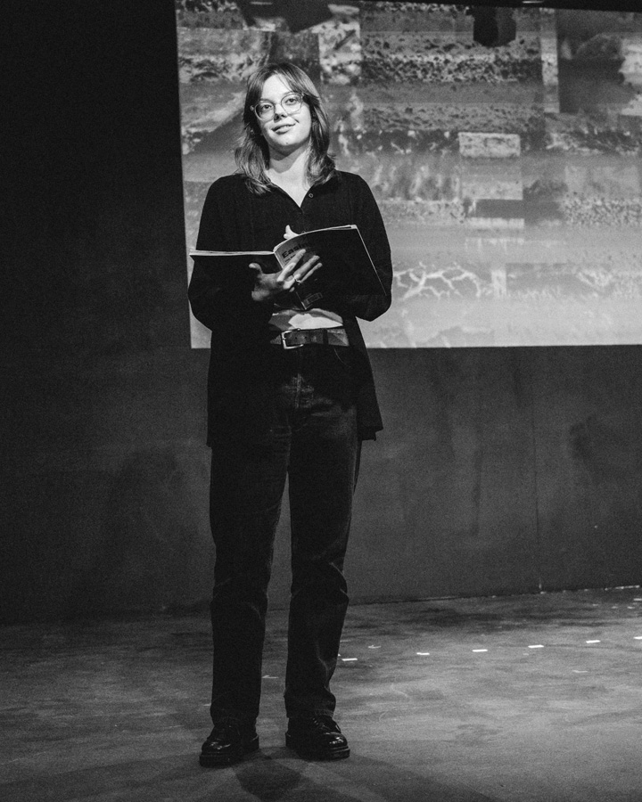 A student performing in a staged reading of The Good Body.
