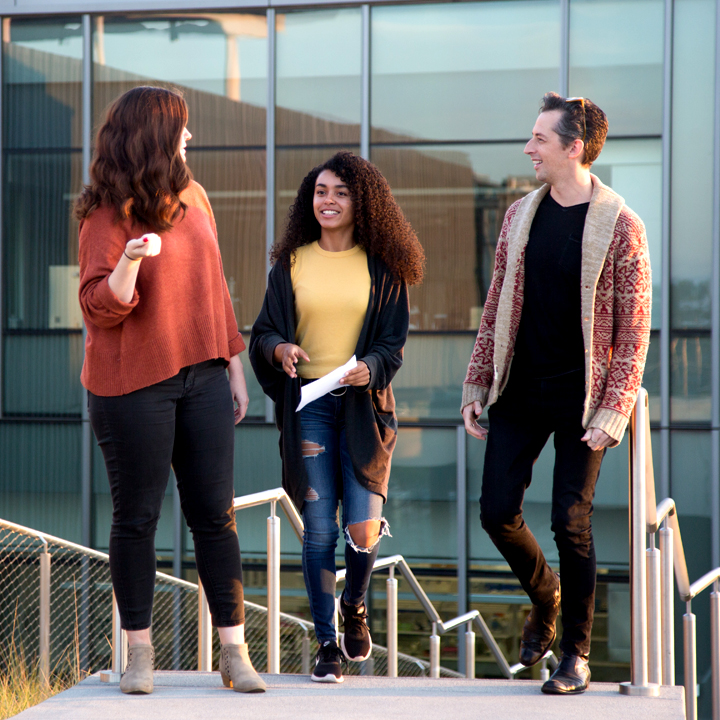 A picture of three MFAPP students talking to each other.