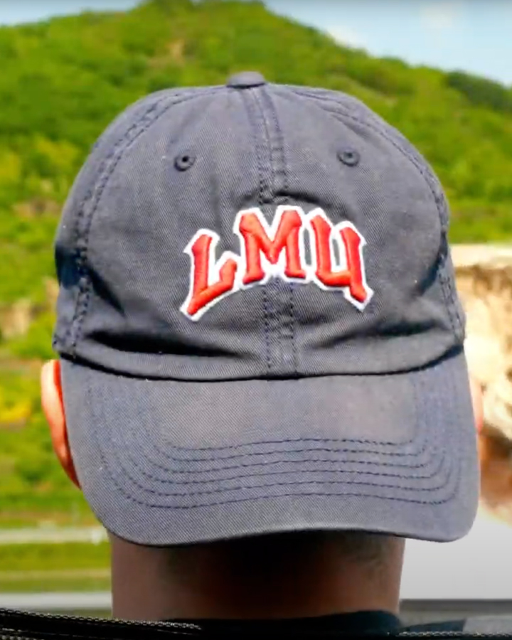 Photo of a theatre student in Europe wearing an LMU hat.