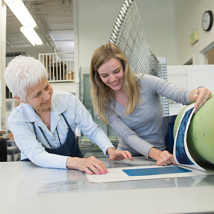 A printmaking professor and student working on a project together