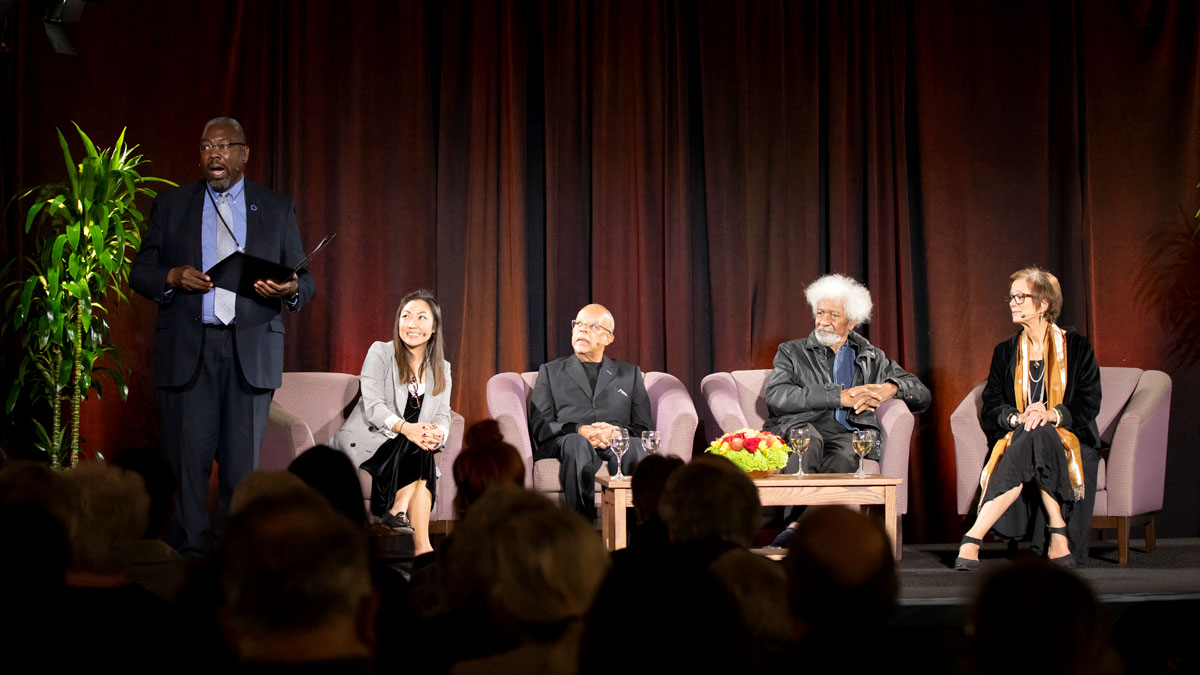Wole Soyinka and Henry Louis Gates, Jr. speaking to an audience, featuring intro from CFA Dean Alexander.