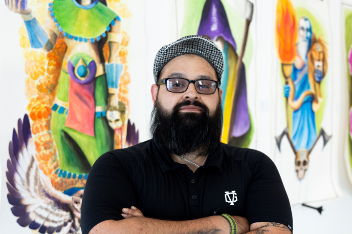 A student poses with his artwork at the 2019 Fine Arts Senior Exhibition.