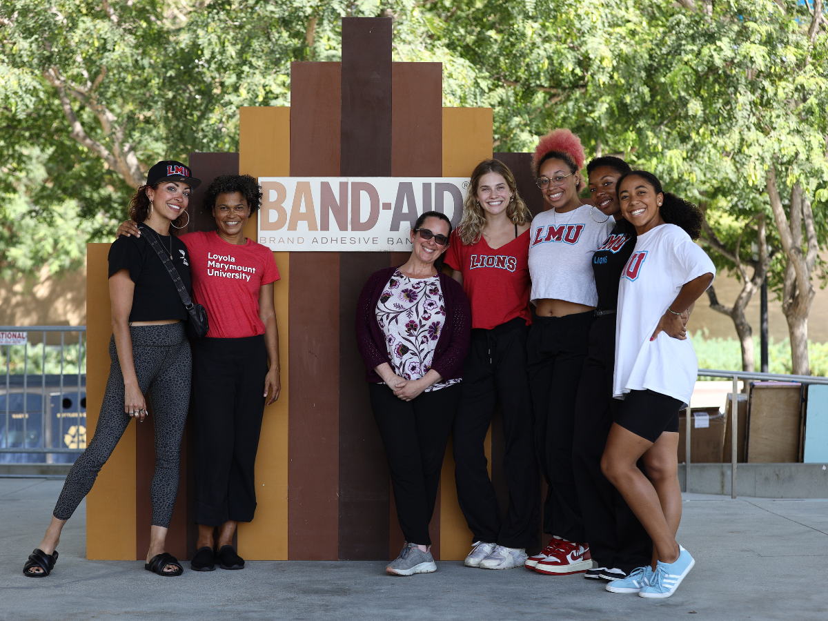 LMU Dance community members pose in front of Band-Aid Brand cutout