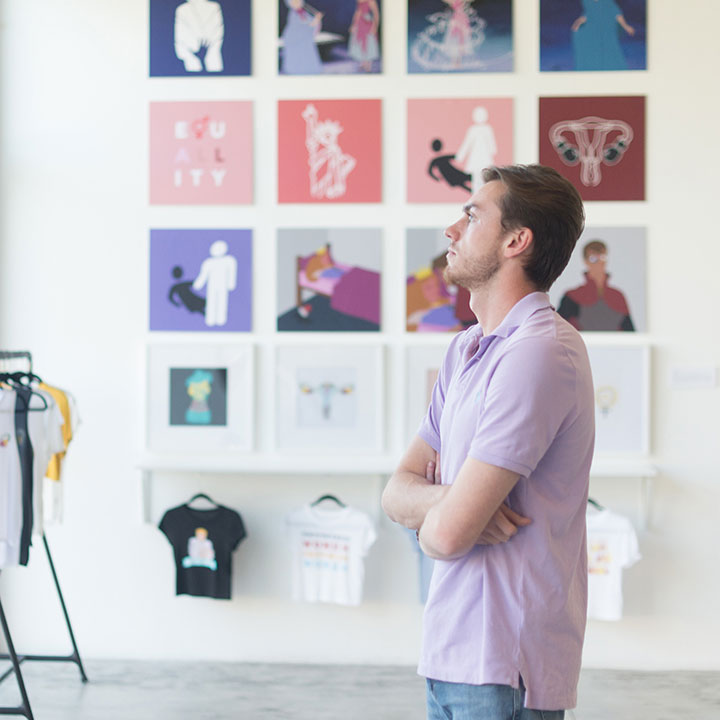 A student admiring a series of works in a gallery