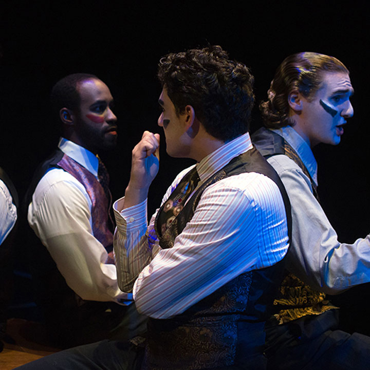 Students sitting in chairs on stage during a performance