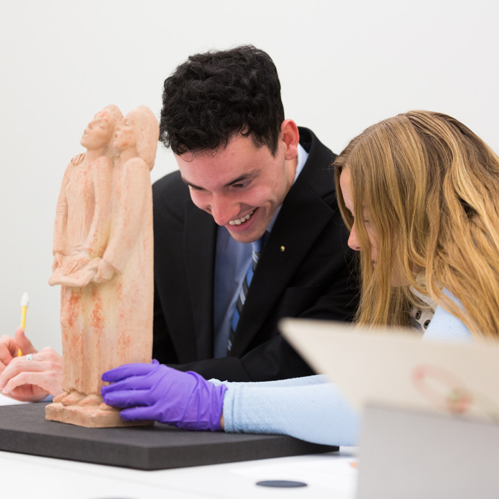Two people examining a sculpture.