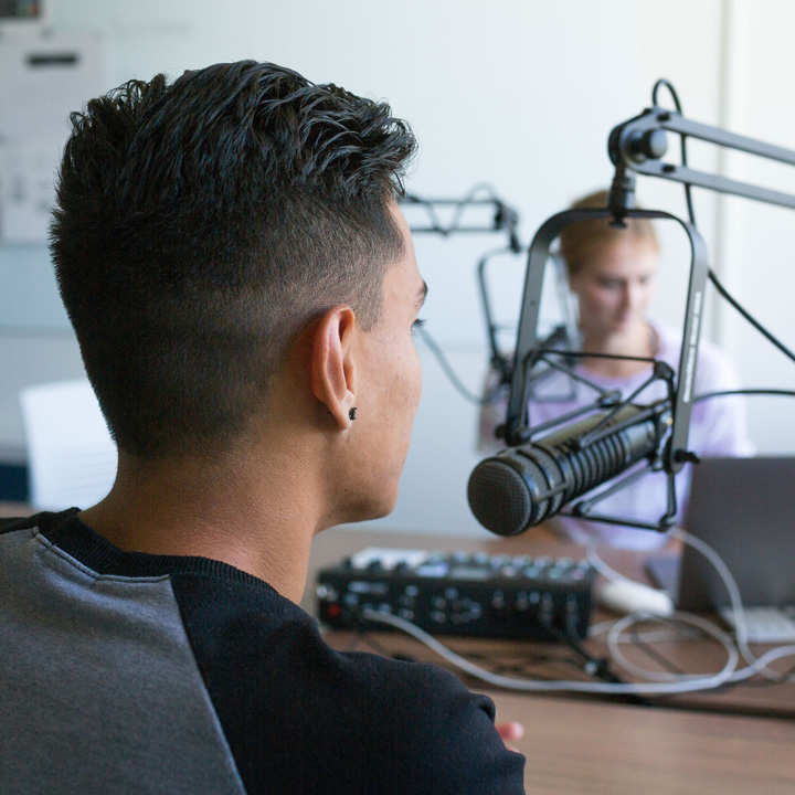 Two people recording a podcast in a studio.
