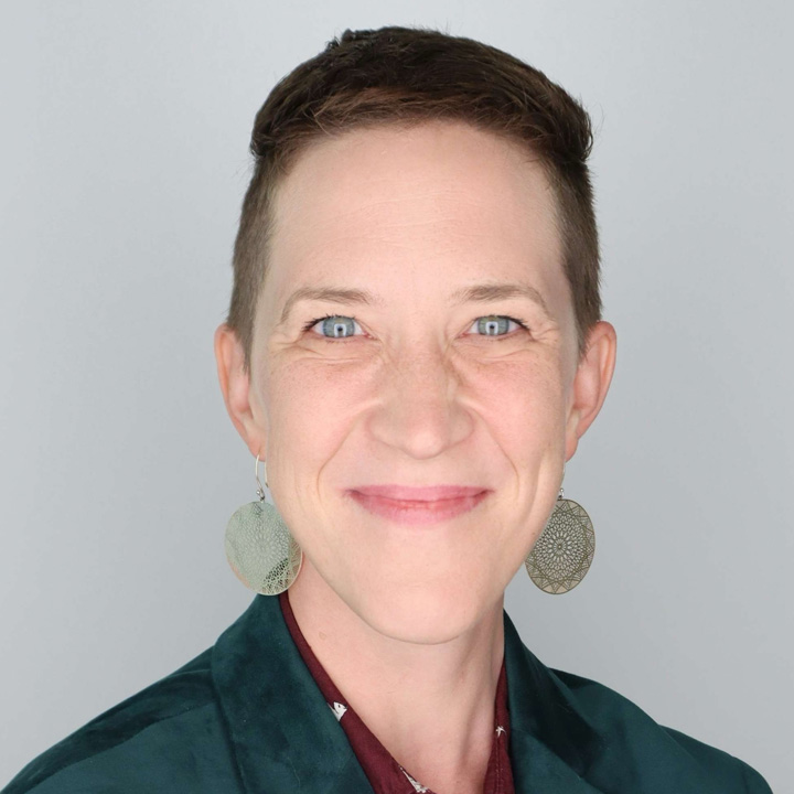 Headshot of Stacey Cabaj in a green and red outfit.