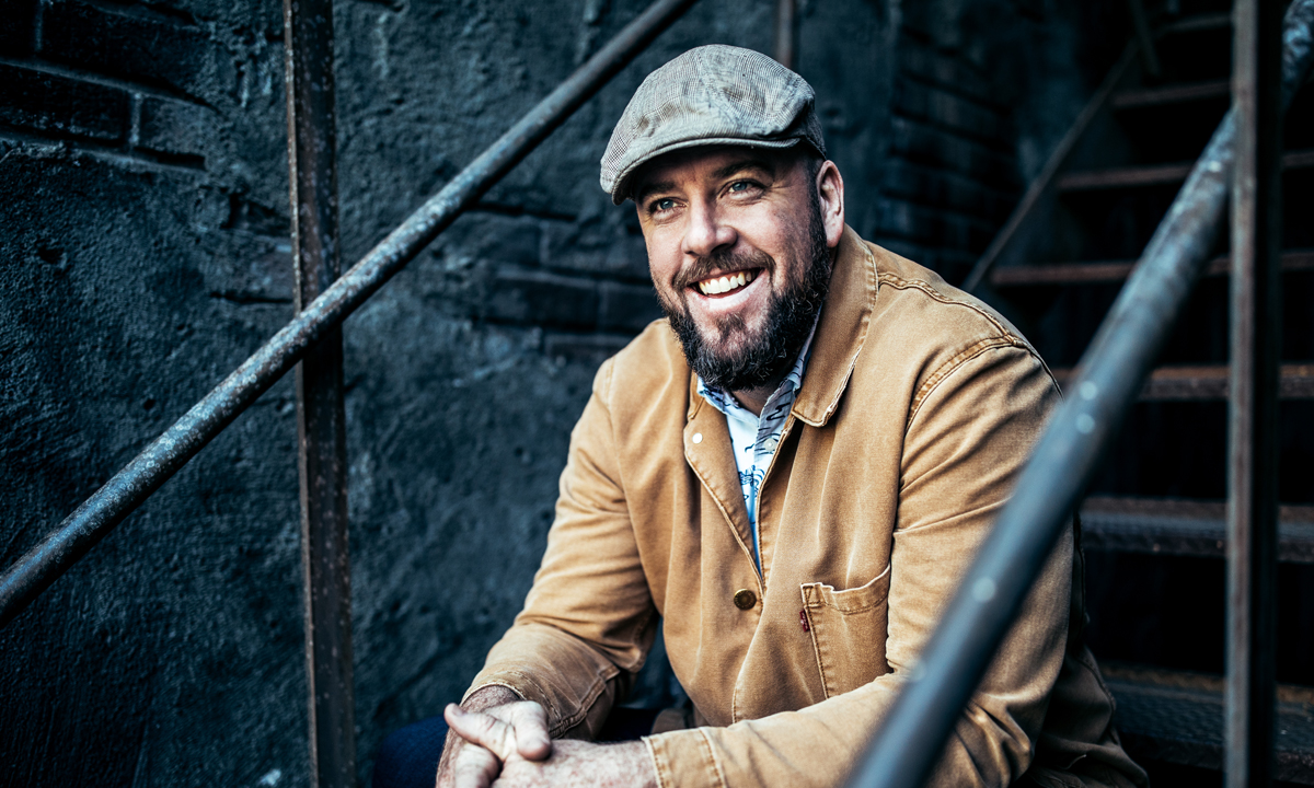 Photo of Chris Sullivan sitting on stairs.